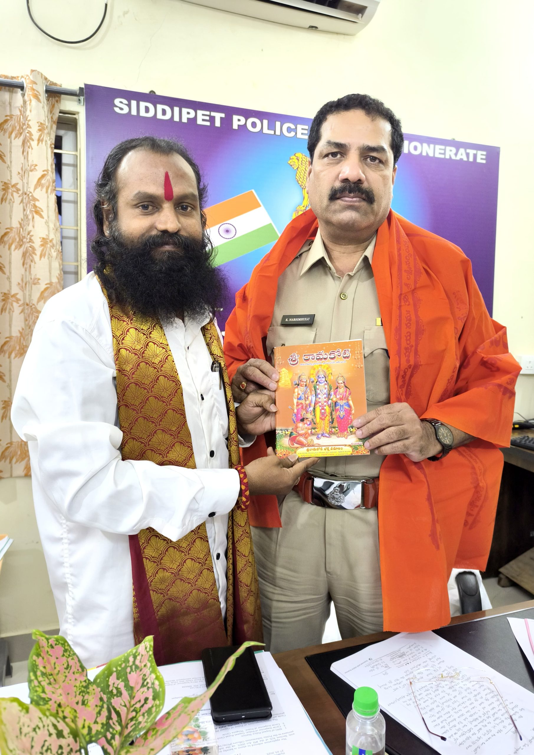 ఏసీపీ కి రామకోటి పుస్తకం అందజేసిన రామకోటి రామరాజు